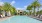 a pool with lounge chairs and umbrellas by a building