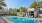 a pool with chairs and umbrellas by a building